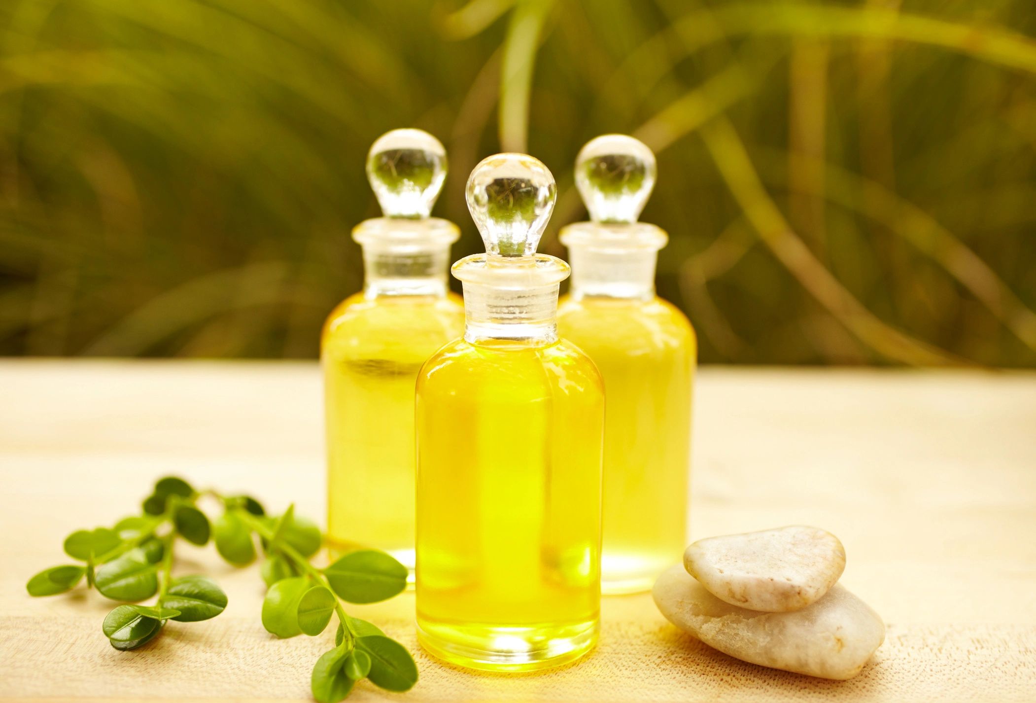 Massage oil bottles with pebbles and a green leaf